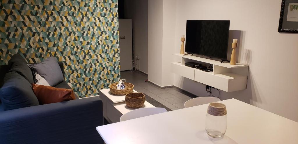 un salon avec un canapé bleu et une télévision dans l'établissement Alquiler Temporal en Nueva Córdoba!, à Córdoba