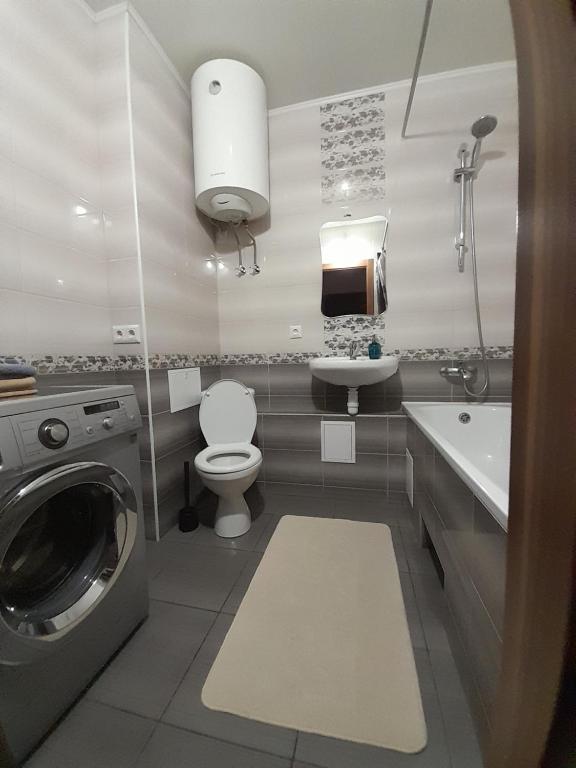 uma casa de banho com uma máquina de lavar roupa e um lavatório em UpTown-Квартира em Vyshhorod