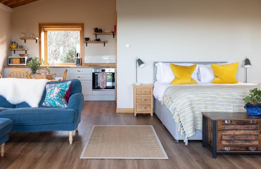 1 dormitorio con 1 cama y 1 sofá azul en The Bothy at Coneloch, en Elgin