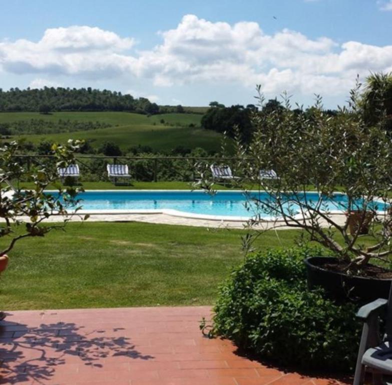 einen Pool mit Stühlen im Hof in der Unterkunft Agriturismo Il Maggio in Manciano