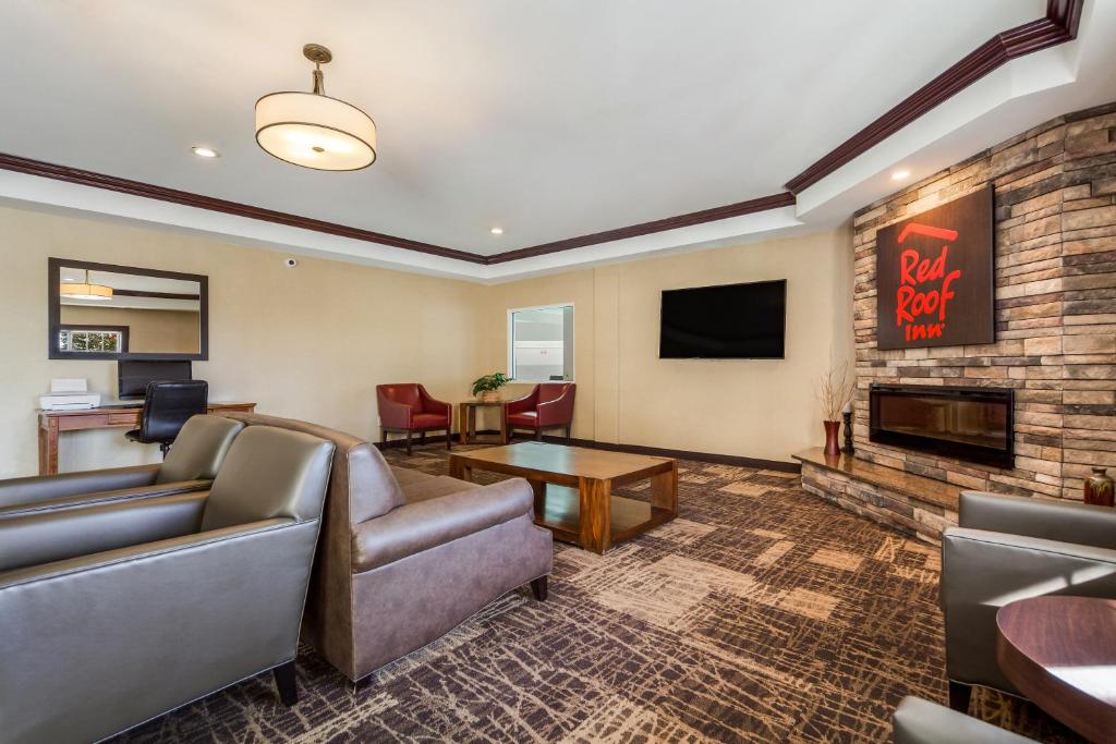 a living room with a couch and a fireplace at Red Roof Inn & Suites Omaha - Council Bluffs in Council Bluffs