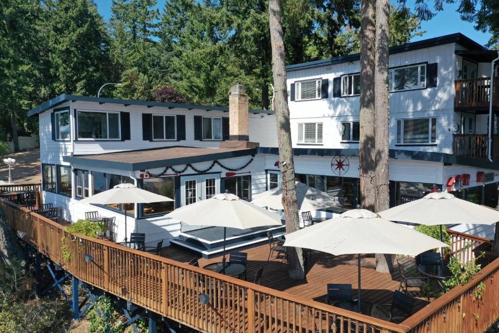 a building with a deck with umbrellas at Raven Point Inn in Ladysmith