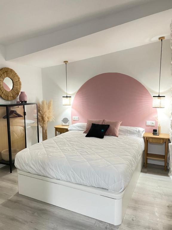 sypialnia z dużym białym łóżkiem z różowym zagłówkiem w obiekcie Pequeña suite independiente al lado Burgas w mieście Ourense