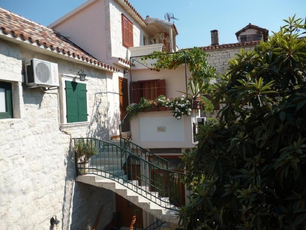 een gebouw met een trap en een groene deur bij Apartments and rooms Jare - in old town in Trogir