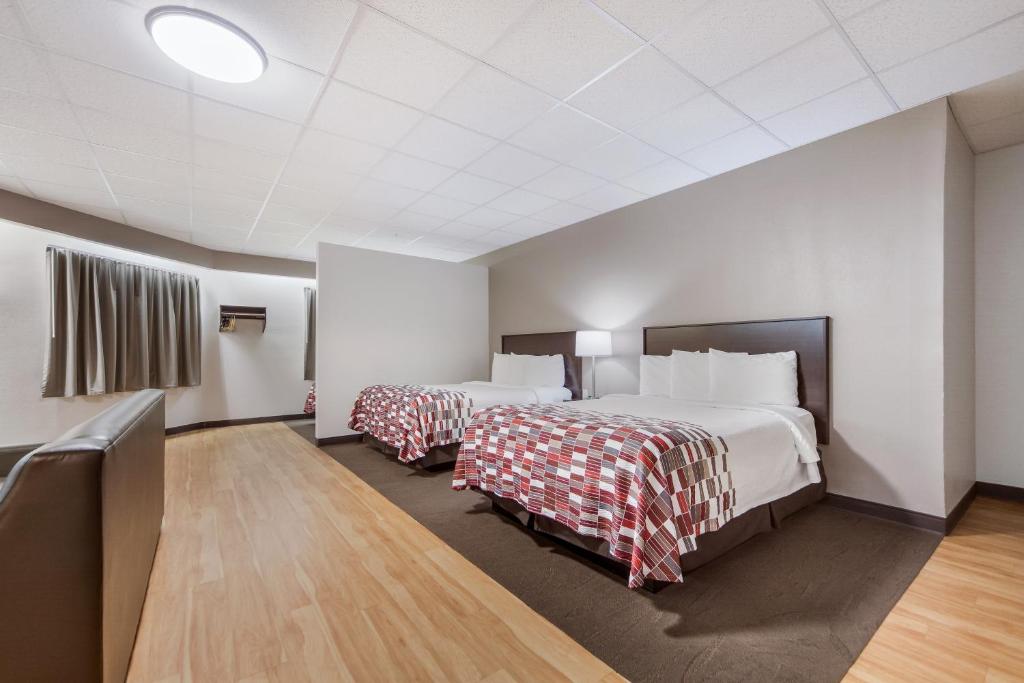 a hotel room with two beds and a television at Red Roof Inn & Suites Omaha - Council Bluffs in Council Bluffs