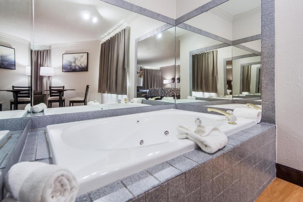 a large bathroom with a tub and a large mirror at Red Roof Inn & Suites Omaha - Council Bluffs in Council Bluffs