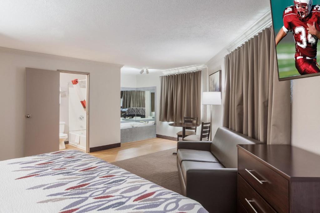 a hotel room with a bed and a flat screen tv at Red Roof Inn & Suites Omaha - Council Bluffs in Council Bluffs