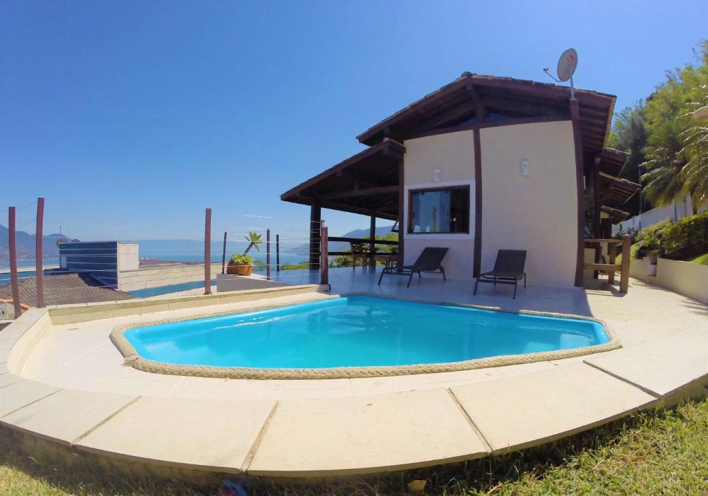 uma piscina em frente a uma casa em Vista espetacular, churrasqueira gourmet e piscina aquecida em Ilhabela