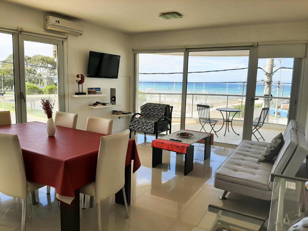 a living room with a dining table and a view of the ocean at Costa Mar in Puerto Madryn