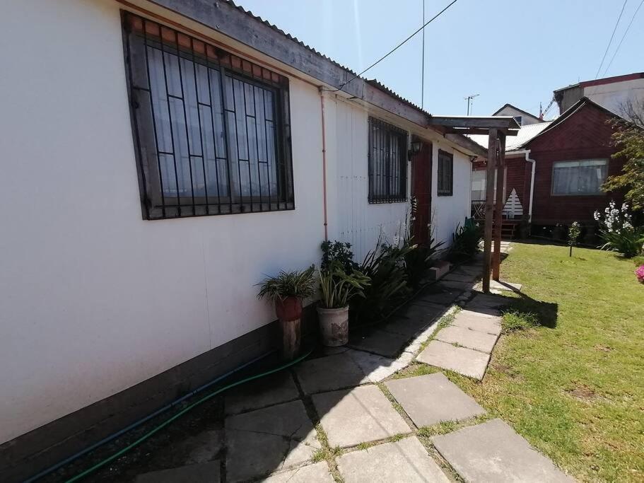 una casa blanca con plantas fuera de ella en Cabaña "Descanso playero", en Quintero