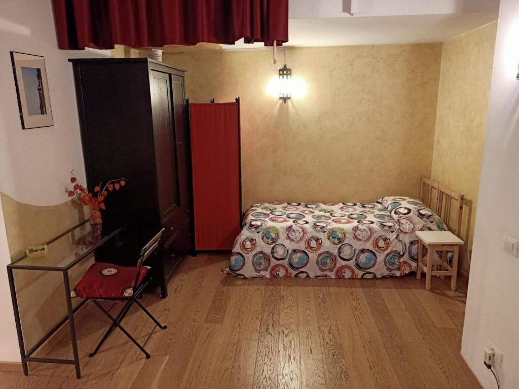 ein Schlafzimmer mit einem Bett, einem Tisch und einem Stuhl in der Unterkunft B&B Eden in Trient