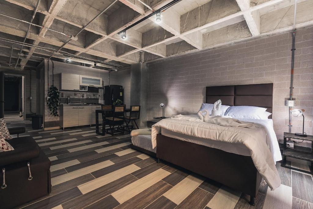 a bedroom with a large bed and a brick wall at Magenta Loft in Medellín