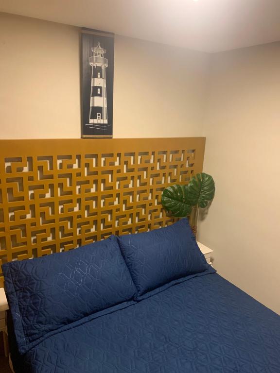 1 dormitorio con cama azul y cabecero de madera en Loft 207 com vista para a piscina e Farol en Laguna