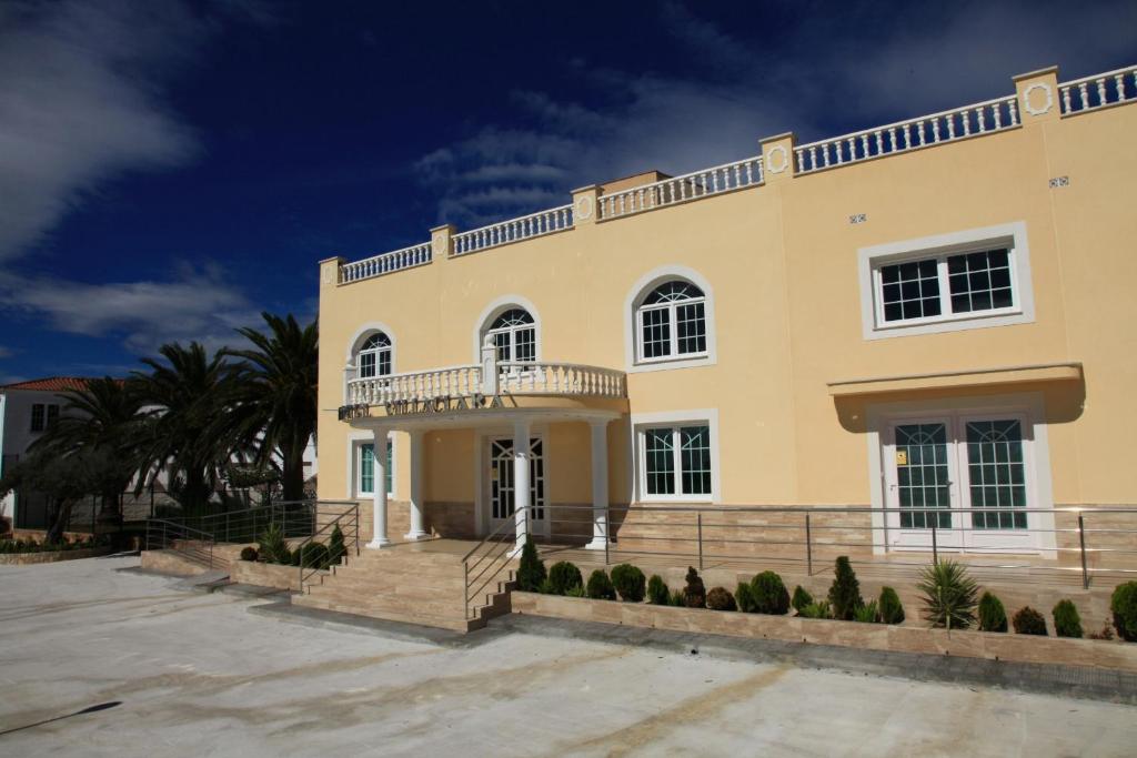 Cette grande maison jaune dispose d'un balcon. dans l'établissement Hotel Villaclara, à Hospitalet de l'Infant
