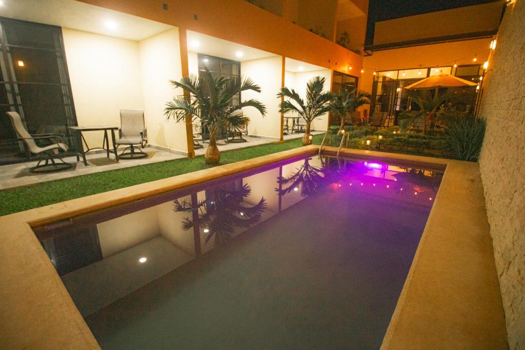 a swimming pool in the middle of a house at night at Hotel Avila in Valladolid