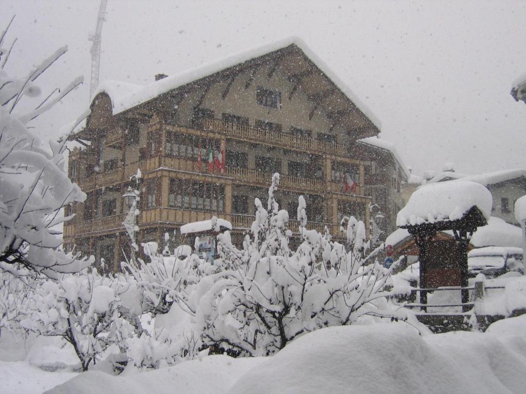 un gran edificio cubierto de nieve frente a él en Casa Smitt, en Alagna Valsesia