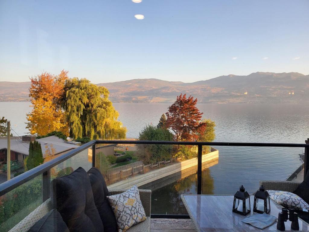 West KelownaにあるWine Country Luxury Waterfront Condoの湖の景色を望む家のバルコニーが備わります。