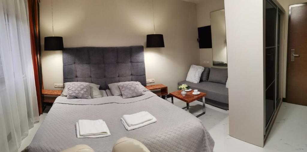 een slaapkamer met een groot bed en een bank bij Apartament prywatny z aneksem kuchennym w hotelu Royal Tulip Sand in Kołobrzeg