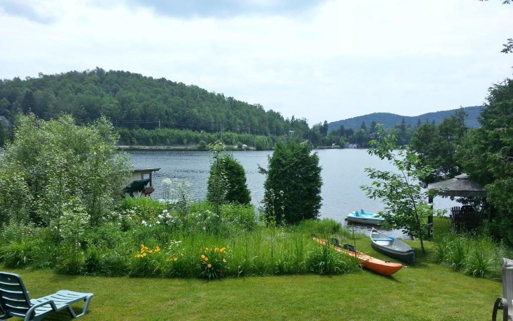 a garden with a view of a lake at Auberge Aux Nuits de Rêve in Sainte-Agathe-des-Monts