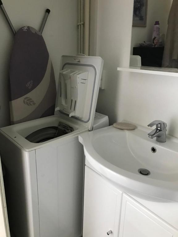 a white bathroom with a sink and a microwave at Studio meublé et lumineux 20m2 in Vittel