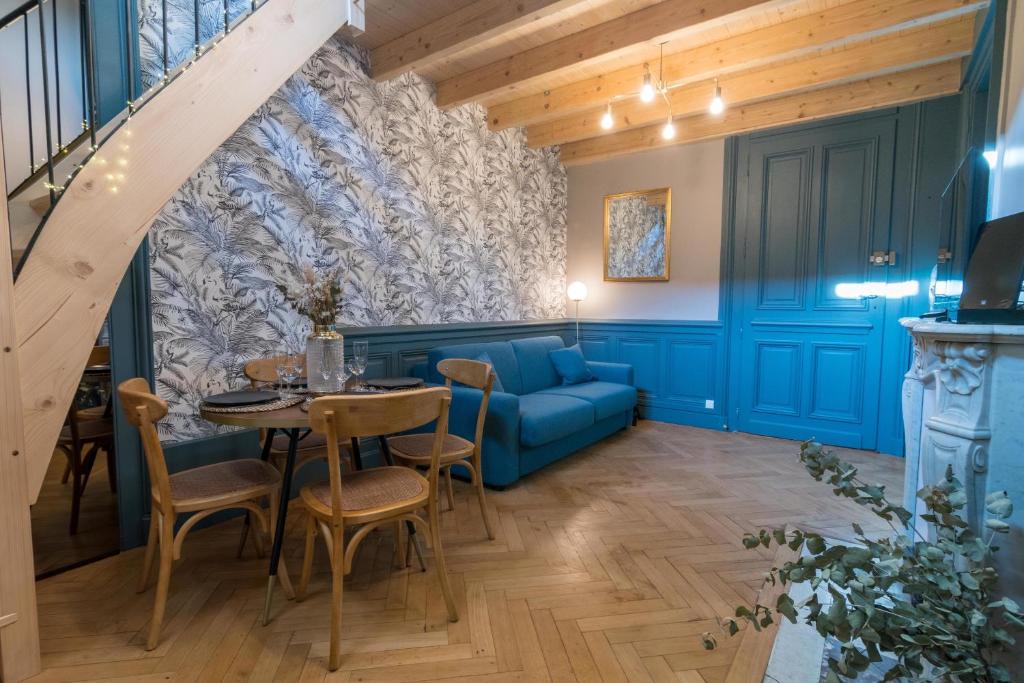 a living room with a blue couch and a table at Les petits boudoirs bernascon in Aix-les-Bains