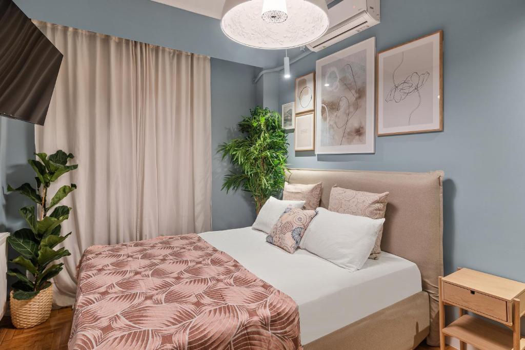 ein Schlafzimmer mit einem Bett und einer Topfpflanze in der Unterkunft Little Athens in Athen