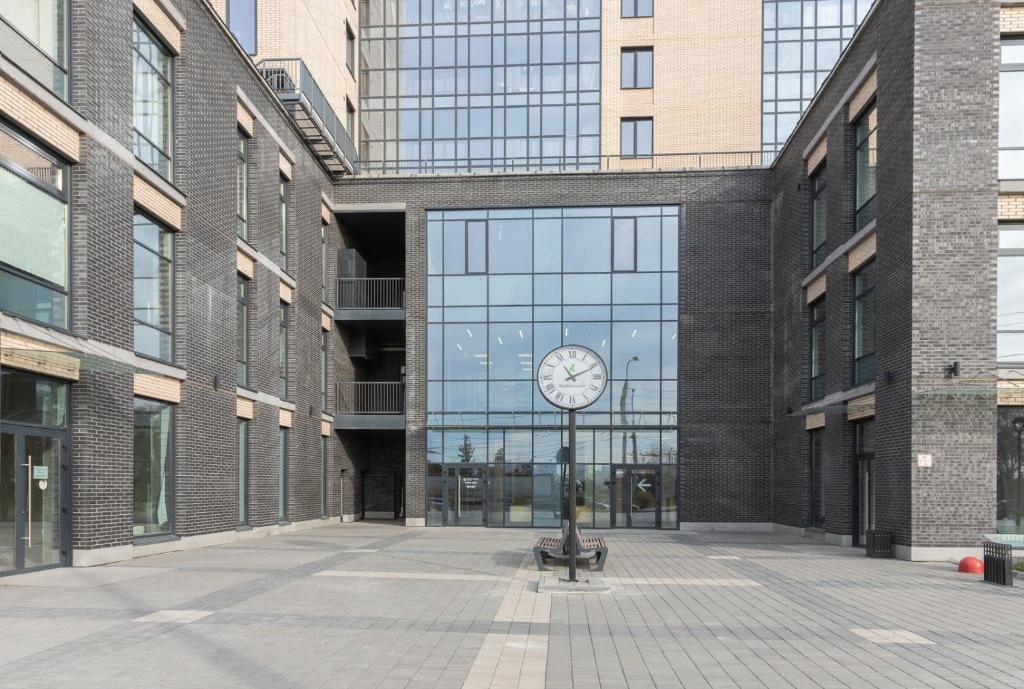 um relógio num poste em frente a um edifício em Гостиниц NET на Большевистской em Novosibirsk