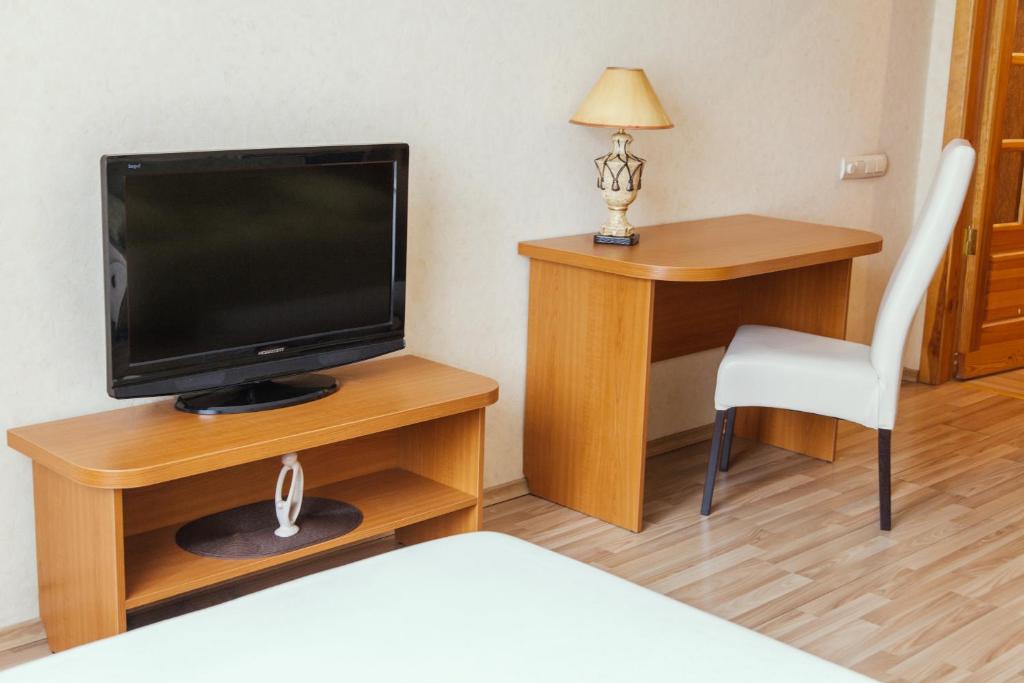 a room with a television and a desk with a chair at TRUSThome in Minsk