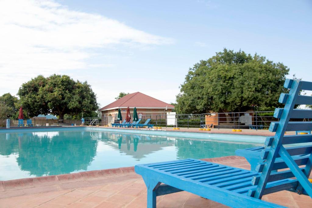 una sedia blu seduta accanto alla piscina di The Sparrow Hotels a Soroti