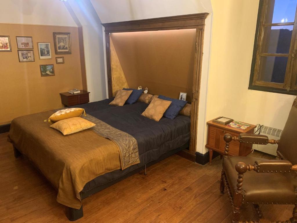 a bedroom with a large bed and a chair at Domaine du Bouysset in Saint-Martin-le-Redon