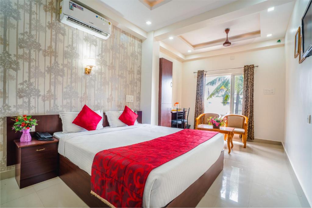 a hotel room with a bed and a red blanket at Almas Residency in Cochin