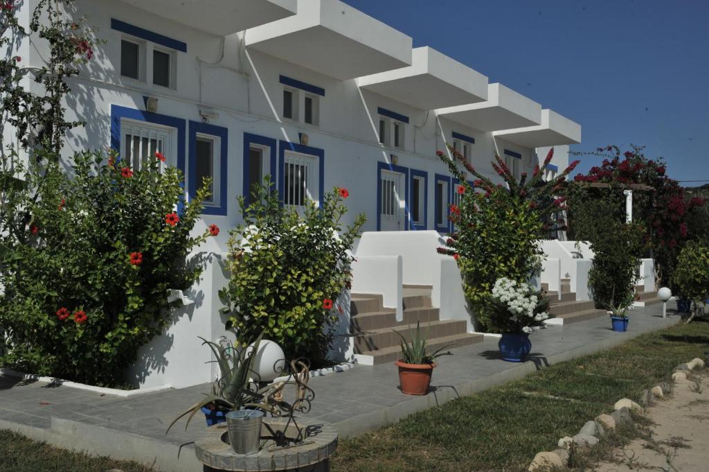 een gebouw met blauwe en witte muren en planten bij Nefeli Apartments in Kefalos