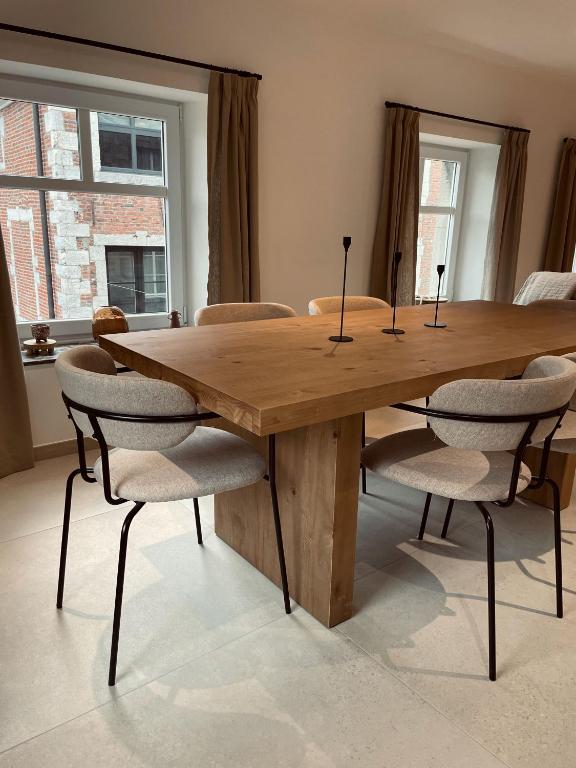 een houten tafel met stoelen eromheen in een kamer bij L'Officine - Résidence Le Cercle in Marche-en-Famenne