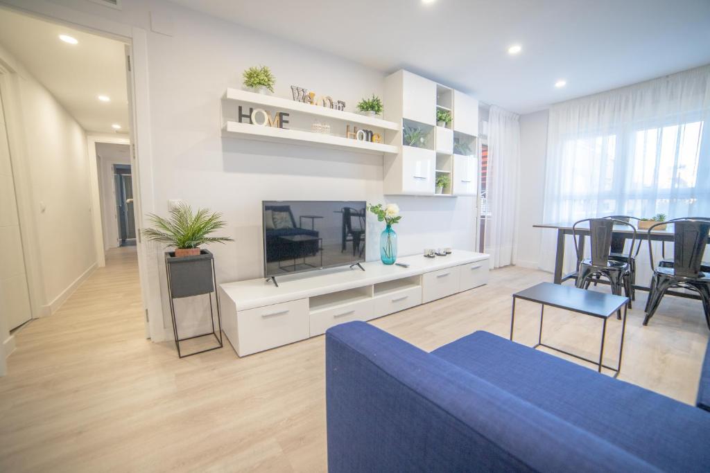 a living room with a blue couch and a tv at Apartment IFEMA-Mar de Cristal II in Madrid