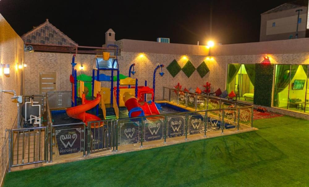 منتجع وسم للشاليهات و قاعات المناسبات في الرياض: منطقة لعب للأطفال مع ملعب في الليل