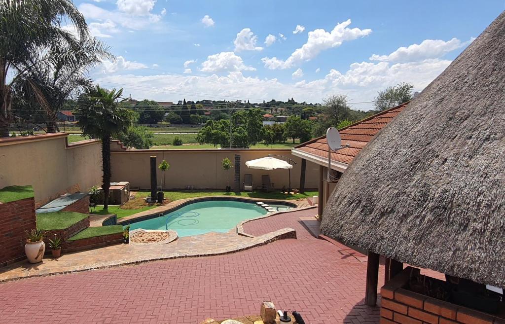 an overhead view of a swimming pool with a roof at LANGA 'S COZY GUESTHOUSE in Pretoria