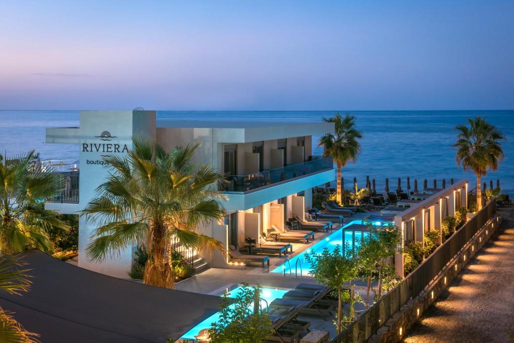 
a beach with palm trees and palm trees at Riviera Boutique Hotel in Stalís
