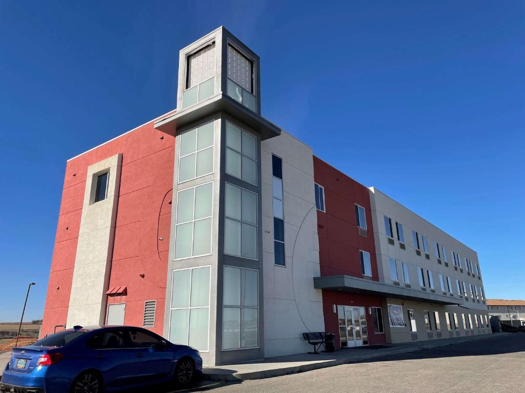 un'auto parcheggiata di fronte a un edificio con una torre dell'orologio di Baymont by Wyndham Williston a Williston