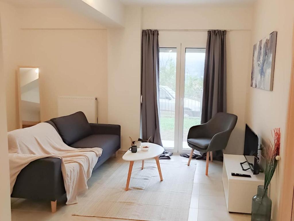 - un salon avec un canapé, une table et une chaise dans l'établissement Cozy modern apartment, à Ioannina