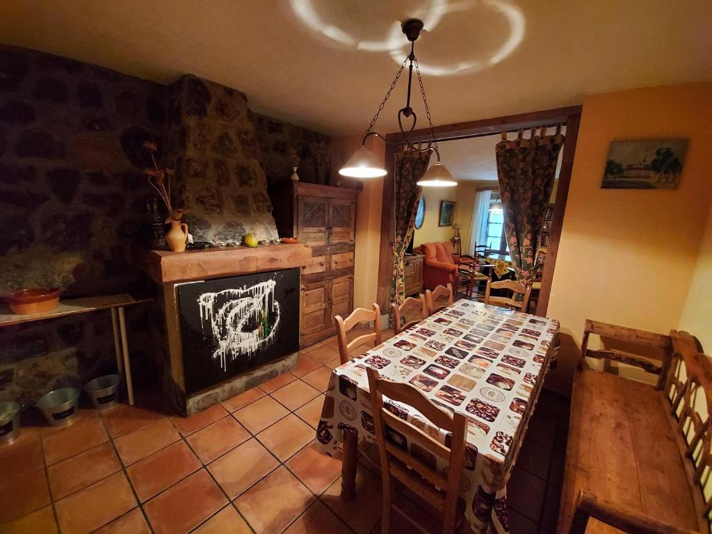 comedor con mesa y chimenea en Casa Rural El Callejo en Hinojosa de Duero