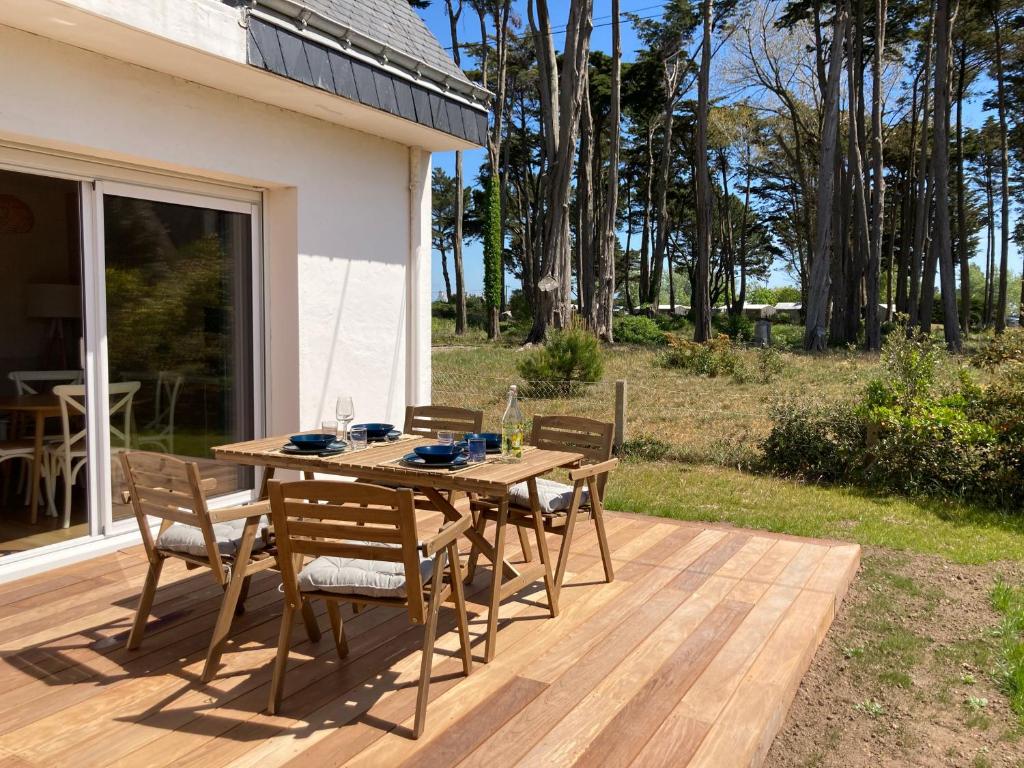 une table et des chaises en bois sur une terrasse dans l'établissement La Villa du Bois d'Amour, à Quiberon