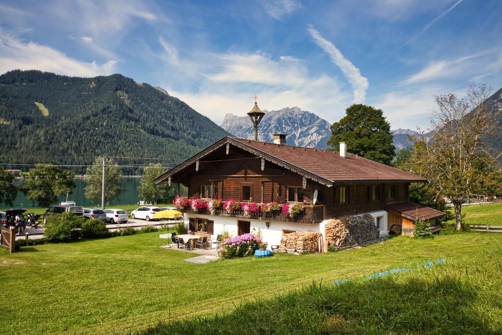 una casa en un campo con montañas en el fondo en Ferienhaus Wille, en Maurach