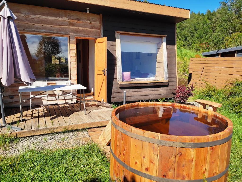 ein großes Holzfass vor einem winzigen Haus in der Unterkunft Tiny House con Tinaja Privada en Pucón in Pucón