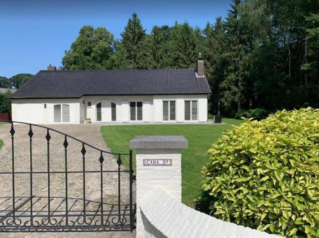 a white house with a fence in front of it at Casa57 in Waasmunster