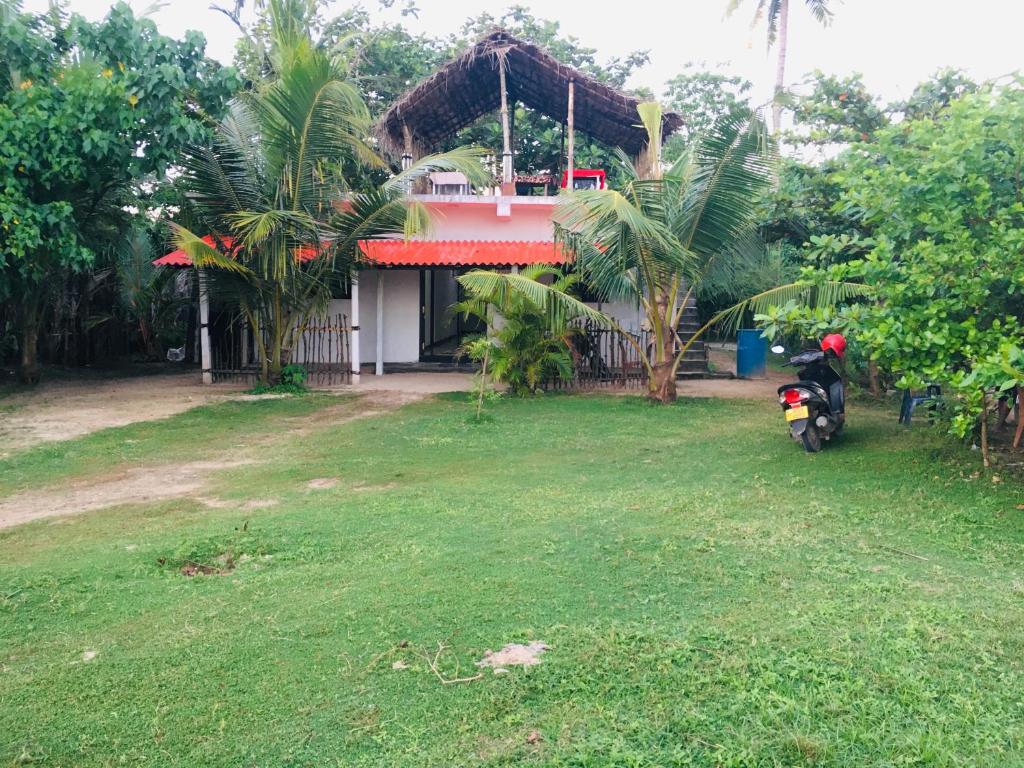 a motorcycle parked in front of a house at Laguna Surfing Stay in Midigama