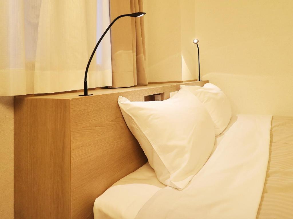 Postel nebo postele na pokoji v ubytování Odawara Terminal Hotel