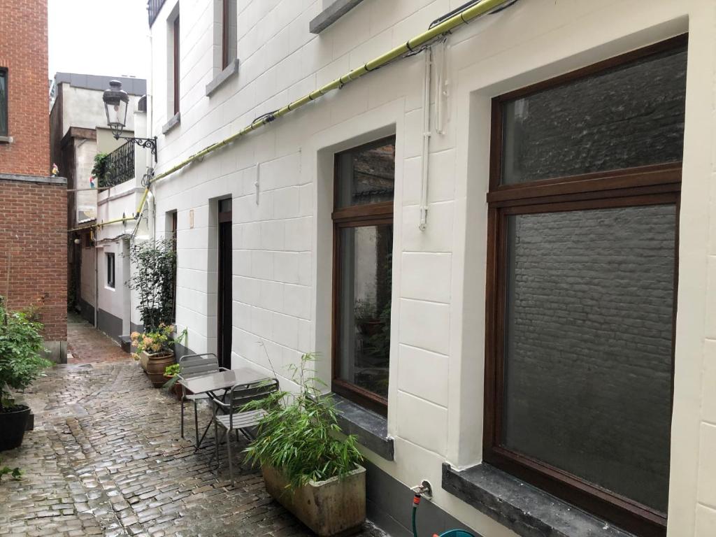 a building with windows and chairs on a street at Petite Impasse privée in Brussels