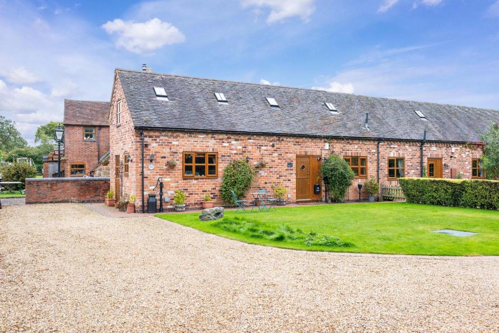 a brick house with a grass yard in front of it at The Pigsty - 3 Bedroom Barn Conversion in Coventry