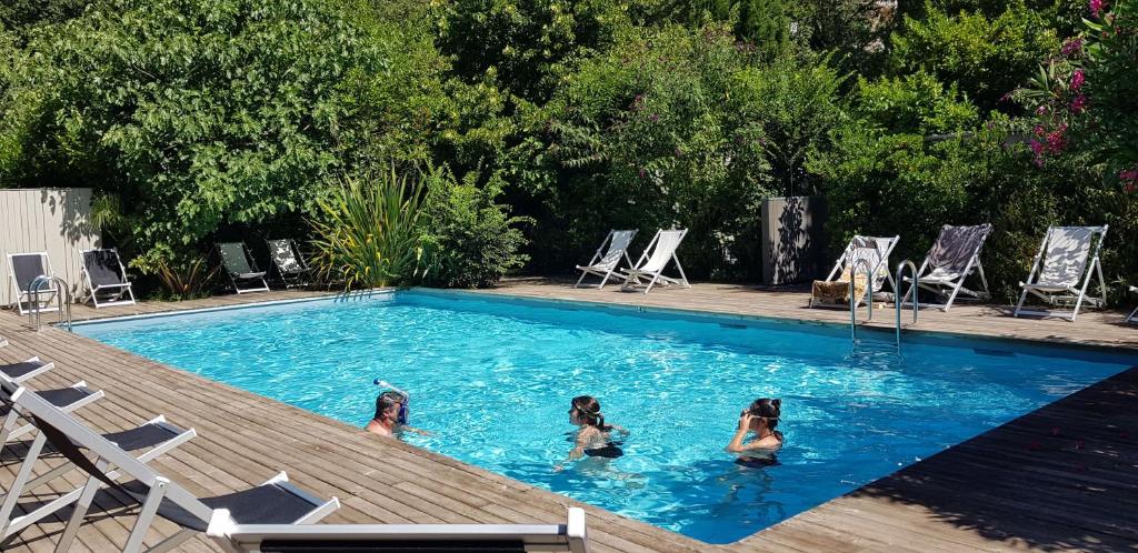Saint-JeannetにあるCamping Les Cent Chênesの三人の女の子がスイミングプールで泳いでいる