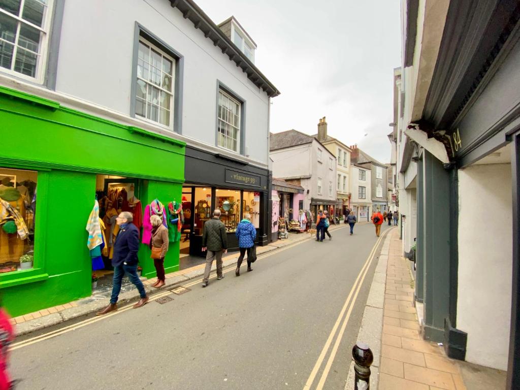 a group of people walking down a street with stores at Rose Apartment in Totnes